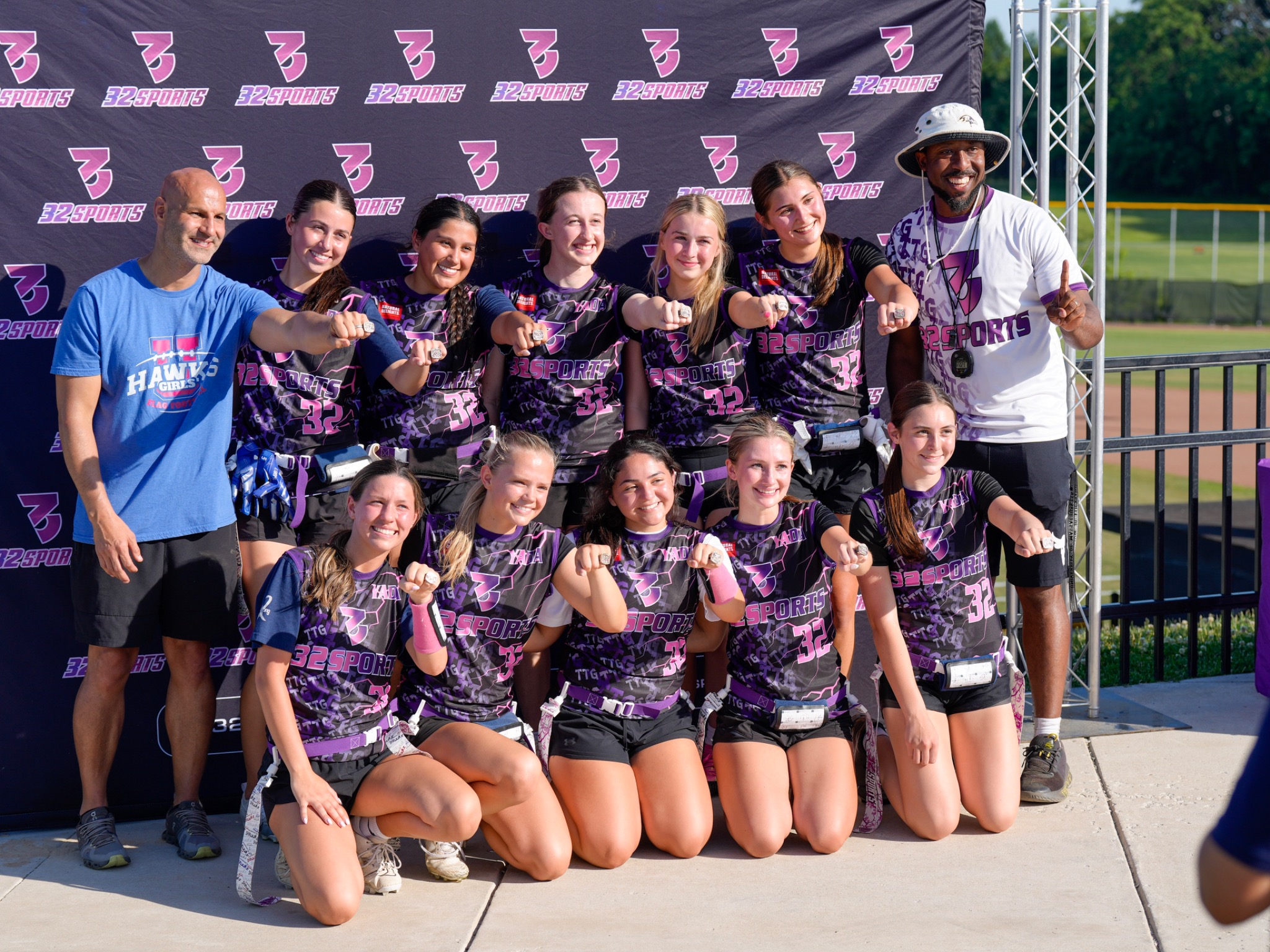 32 Sports girls flag football team showing their championship rings